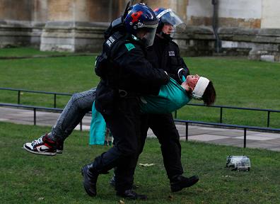 A victim of police brutality carried away by two London cops