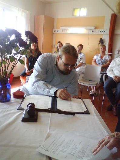 Martin signs the wedding certificate